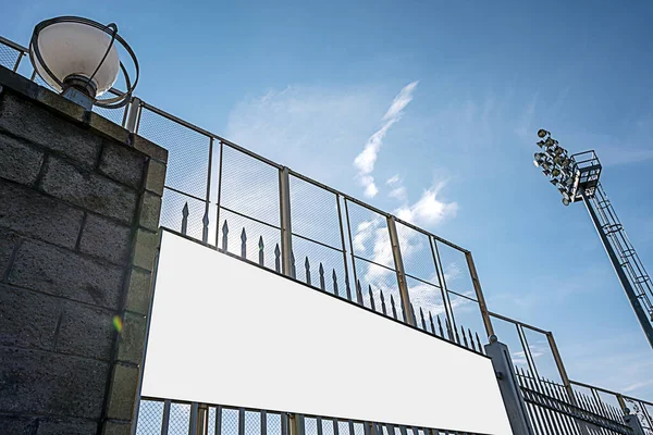 Şehir stadyumunun demir çitlerine sabitlenmiş beyaz vinil pankart reklamı. — Stok fotoğraf