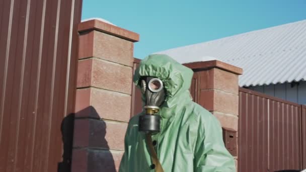 Pessoa andando perto de cerca em equipamento de proteção durante a pandemia — Vídeo de Stock