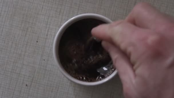 Uomo con cucchiaino di metallo in mano mescolando caffè istantaneo in tazza — Video Stock