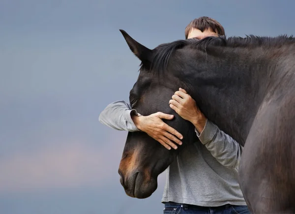 Man omfamnar en häst — Stockfoto