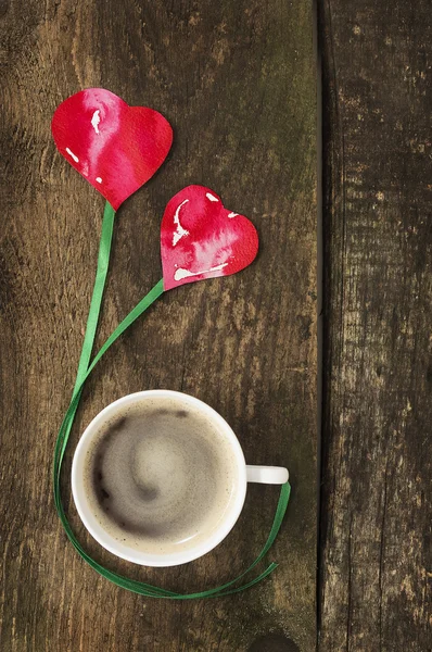 Xícara de café com dois corações na velha mesa de madeira — Fotografia de Stock