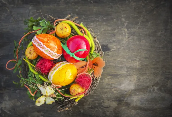 Œufs de Pâques colorés dans le nid sur du vieux bois — Photo