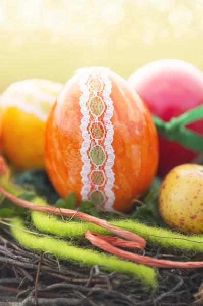 Oranje decoratieve ei met linten in nest voor Pasen — Stockfoto