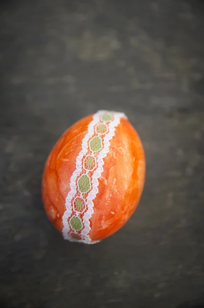 Orange easter egg with lace ribbon on old wood — Stock Photo, Image