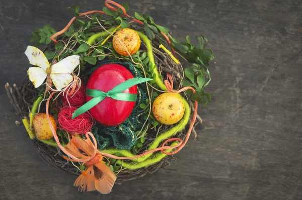 Rode Paasei in bird's nest met decoraties — Stockfoto