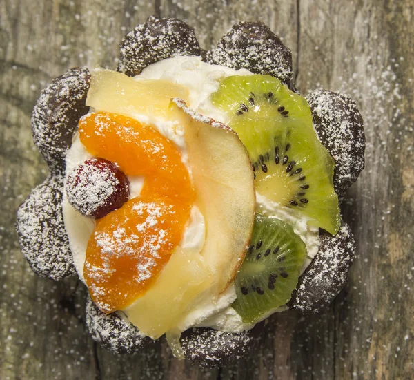 Fruit tart with chocolate on old wood — Stock Photo, Image