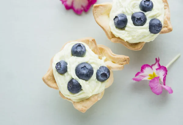 Vanilyalı krema ve çiçekler ile üzümlü tart — Stok fotoğraf