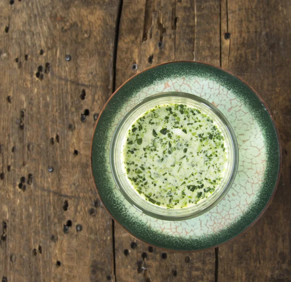 Зеленый коктейльный суп в стеклянном йогурте на старом дереве — стоковое фото