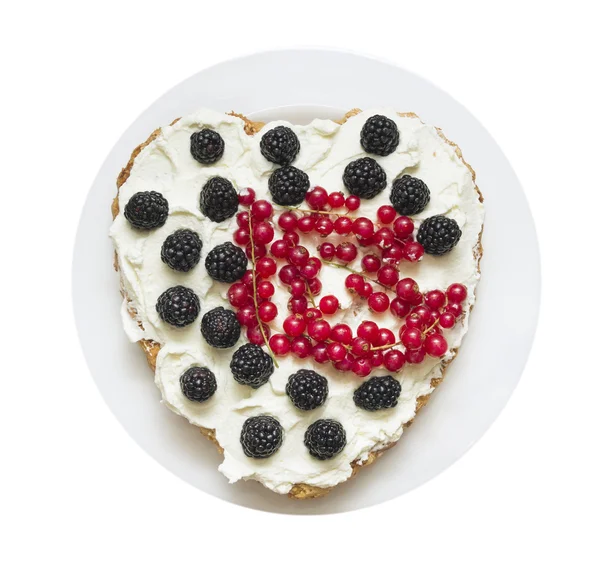 Heart-shaped cake with whipped cream and berries in plate, isolated on white background — Stock Photo, Image