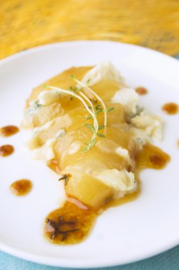 pişmiş plaka üzerinde gorgonzola peyniri ve kekik soslu karamelize armut