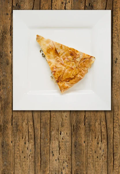 Piece of turkish pie, burek, on old wood — Stock Photo, Image