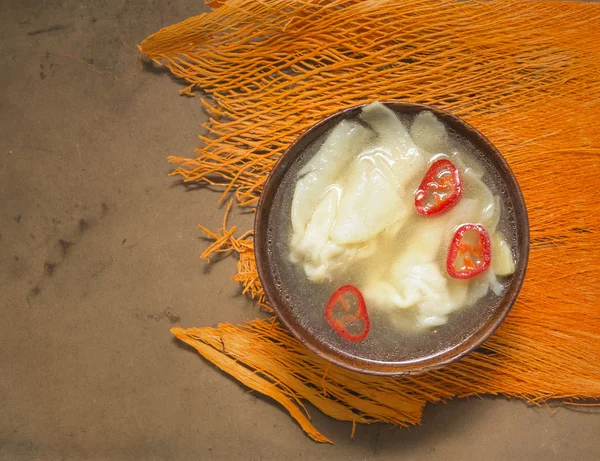 Wantan soep met chili in houten kom op oranje tafel deco — Stockfoto