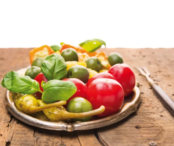 Legumes antipasti italianos com manjericão na velha mesa de madeira — Fotografia de Stock