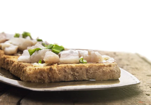 Tostadas con arenque salado y cebolla en bandeja metálica, aisladas — Foto de Stock