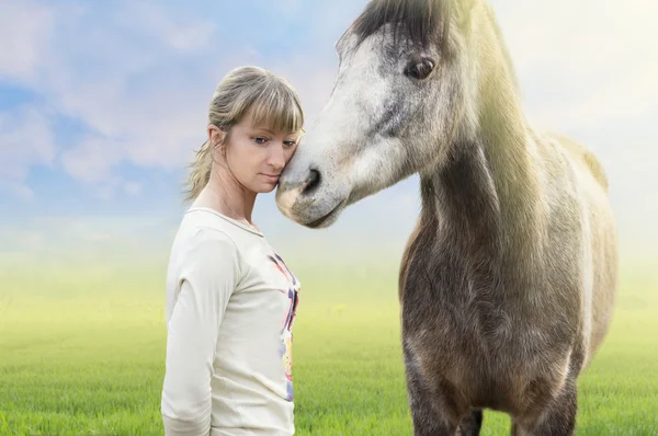 Cavalo abraço com mulher, equitação, fundo de verão com grama verde — Fotografia de Stock