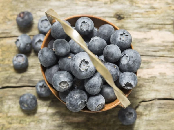 Old basket with blueberries on wooden table, top view — Stock Photo, Image