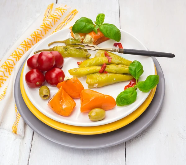 Wymieszać włoskich przystawek, oliwki, pomidory, ostra papryka, nadziewane papryka z serem w trzy kolorowe płytki — Zdjęcie stockowe