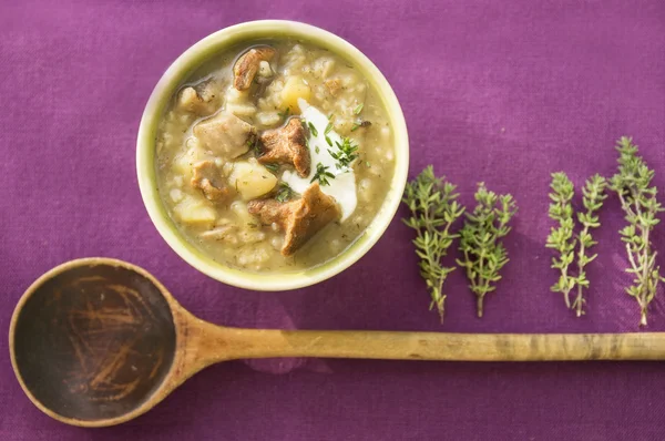 Wild mushroom soup with rice, old wooden spoon, purple cloth, thyme — Stock Photo, Image