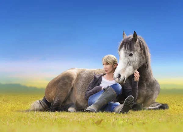 Chica con caballo árabe gris yacen en el campo amarillo — Foto de Stock