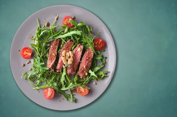 dana biftek orta, ruccola salata domates ve ceviz, gri plaka, mavi arka plan, alanı Kopyala