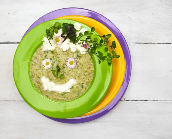 Spring green soup with wild herbs in colorful plates , decorations smile face — Stock Photo, Image