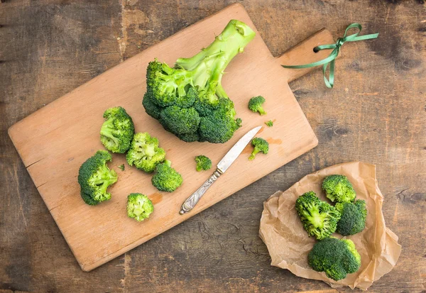 Broccoli cabbage on cutting board with vintage knife and crumpled paper — Stock Photo, Image