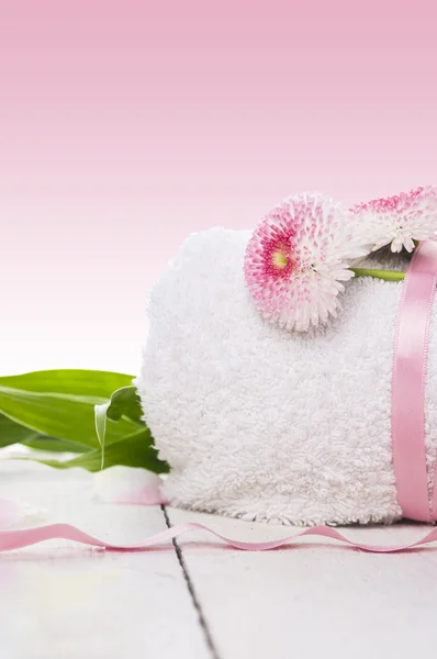 Weißes zusammengerolltes Handtuch mit Seidenband und Gänseblümchen, Wellness — Stockfoto