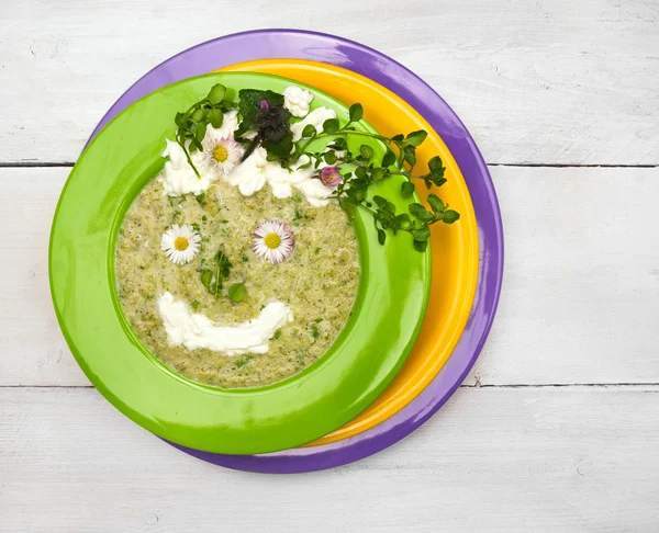 Spring green soup with wild herbs in colorful plates , decorations smile face — Stock Image Spring green soup with wild herbs in colorful plates , decorations smile face Royalty Free Stock Images