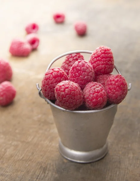 Bucket of ripe raspberries on wooden table — Stock Photo, Image