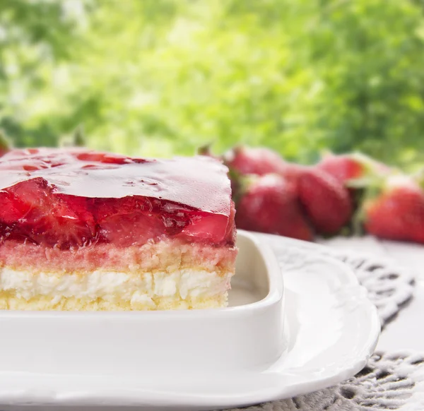 Tarte aux fraises à la crème et gelée dans le jardin d'été — Photo