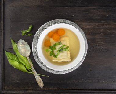 Clear soup with German ravioli,carrots and ramson clipart