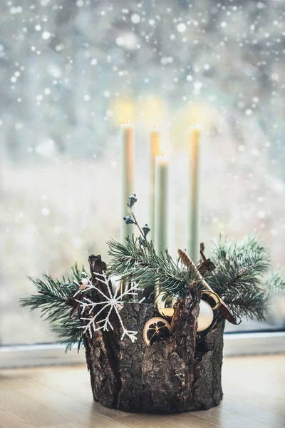 舒适舒适的圣诞家居装饰 四支燃烧的蜡烛 雪松枝条和雪花矗立在雪天背景的窗前 节日快乐安静的生活 第四次来了圣诞花环 — 图库照片