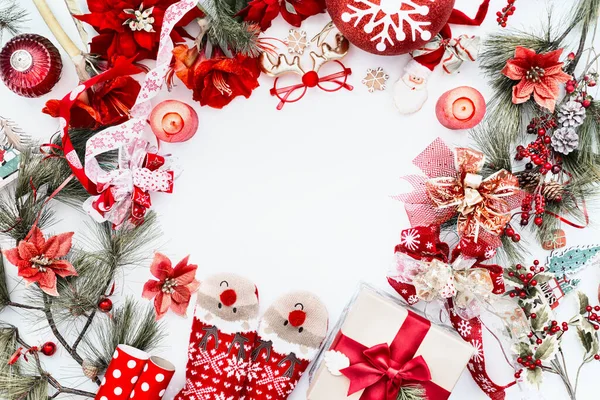 框架由红色圣诞装饰 可笑的鹿袜和白色背景的礼品盒与冷杉树枝和蜡烛制成 顶部视图 圣诞节的背景平躺在床上 — 图库照片