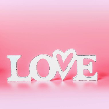 Pastel pembe arka planda beyaz kelime aşkla soyut aşk kavramı. Yaratıcı romantik düzen. Düğün kartı. Boşluğu kopyala