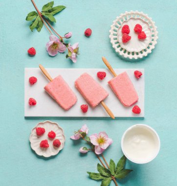 Ev yapımı ahududu yoğurtlu dondurma, açık mavi turkuaz arka plan, üst manzara, düz yatak. Buzlu dondurma. Yaz yemeği.