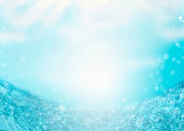 Mavi gökyüzü arka planında deniz ya da okyanus suyu, güneş ışınlarıyla. Yaz arkaplanı