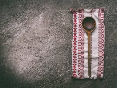 Kırsal taş mutfak masasının üzerinde mutfak peçetesi olan eski ahşap kaşık, üst manzara. Ulusal mutfak yemekleri ve yemek pişirme geçmişi. Tasarımınız için alanı kopyalayın