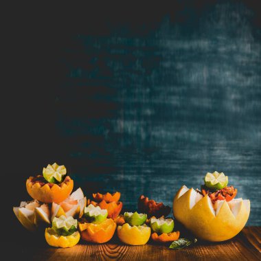 Renkli narenciye meyvelerinin yarısı masada, arka planda. Uzayı kopyala Tropik turunçgiller. C vitamini. Sağlıklı yaşam tarzı.