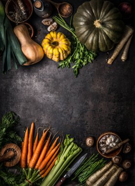 Sonbahar mevsimsel gıda arka planında çeşitli renkli balkabakları ve organik çiftlik sebzeleri var. Koyu mutfak masasında, üst tarafta. Sağlıklı vejetaryen yemekleri. Şükran Günü ya da Cadılar Bayramı tarifleri. Mevsimlik