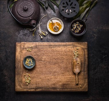Healthy herbal tea background with chamomile flowers, tea pot and honey. Top view. Copy space for your design. Frame