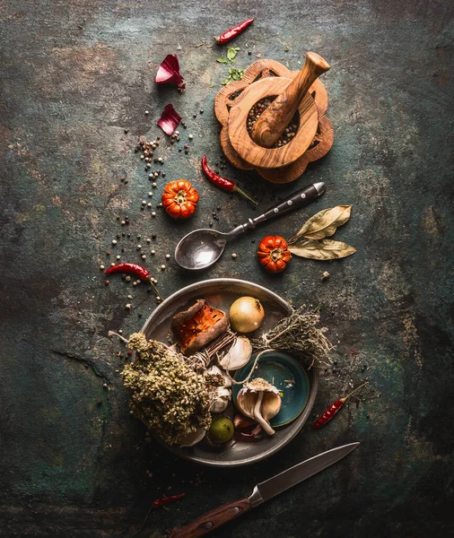 Kurutulmuş baharatlar, karanlık arka planda eski mutfak aletleriyle pişirilmiş otlar ve mekanlar. Üst Manzara. Düz yatıyordu