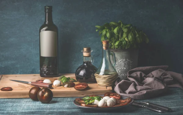 Voedsel Stilleven Met Olie Flessen Mozzarella Tomaten Keukenkruiden Pot Keukentafel — Stockfoto