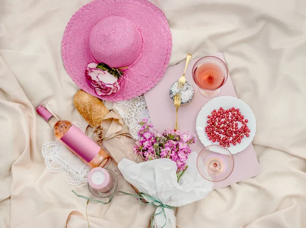 野餐用的平底锅铺在米黄色的毯子上 上面有粉色的稻草太阳帽 玫瑰酒 美味的奶酪和漂亮的眼镜 顶部视图 美学野餐概念 — 图库照片