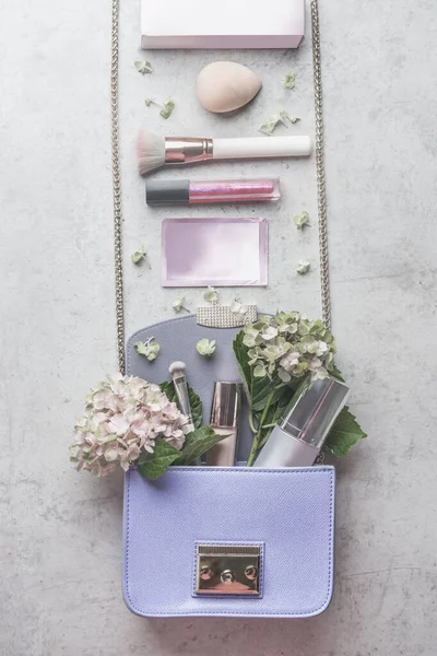 小紫丁香手提包 上有水仙花和各种化妆品 美的概念 — 图库照片