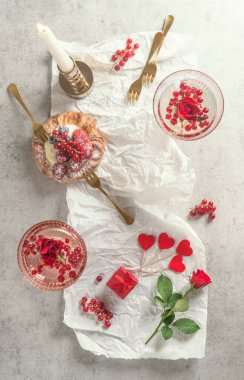 Kokteyl bardakları şampanya, pasta ve gül çiçekli bir sürü kırmızı kalp. Üst Manzara. Romantik kahvaltı.