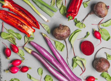 Biber, patlıcan, pancar ve turpla soluk gri mutfak masasında sebze desenli arka plan. Renkli mevsimlik sebzeler. Üst görünüm.