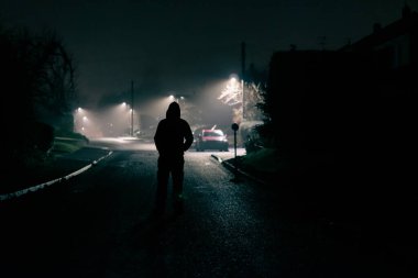 Kapüşonlu korkunç bir figür. Sakin bir banliyö sokağında yolun ortasında dikiliyorum. Sisli bir kış gecesinde