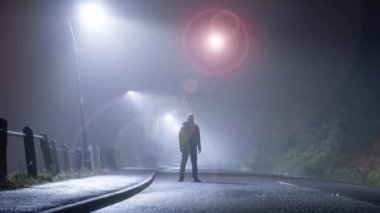 Bir bilim kurgu kurgusu. Yolda duran bir adamın resmi. Geceleri gökyüzünde parlayan, uzaylı bir UFO ile. 