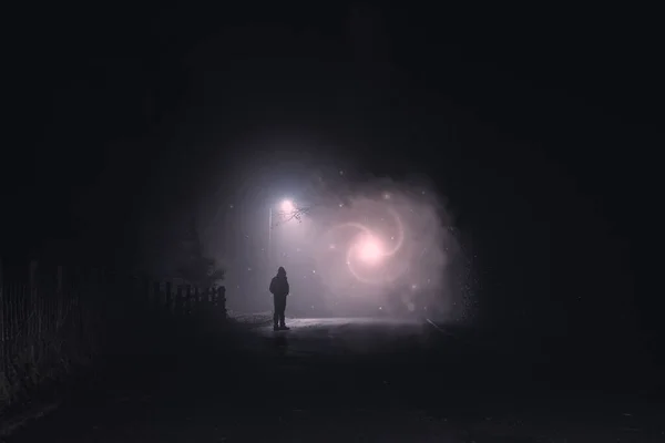 科幻小说 一个幻想的概念 一个人在一个恐怖的 雾蒙蒙的冬夜 在街灯下凝视着一个发光的光之门和星星 — 图库照片