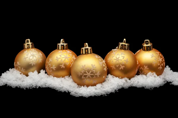 Gouden kerstballen met sneeuw geïsoleerd op zwart — Stockfoto